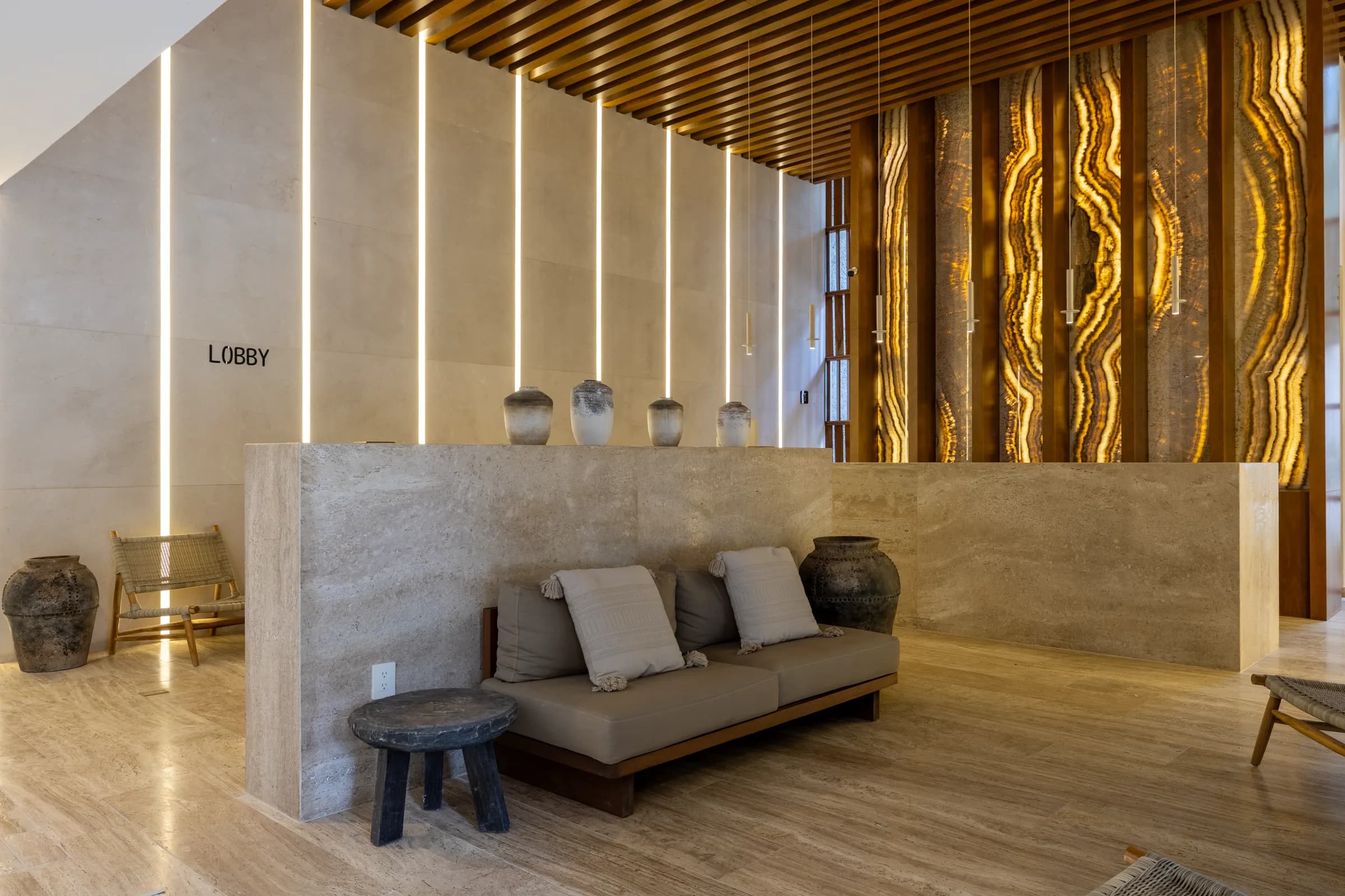Lobby con recepción de mármol travertino
