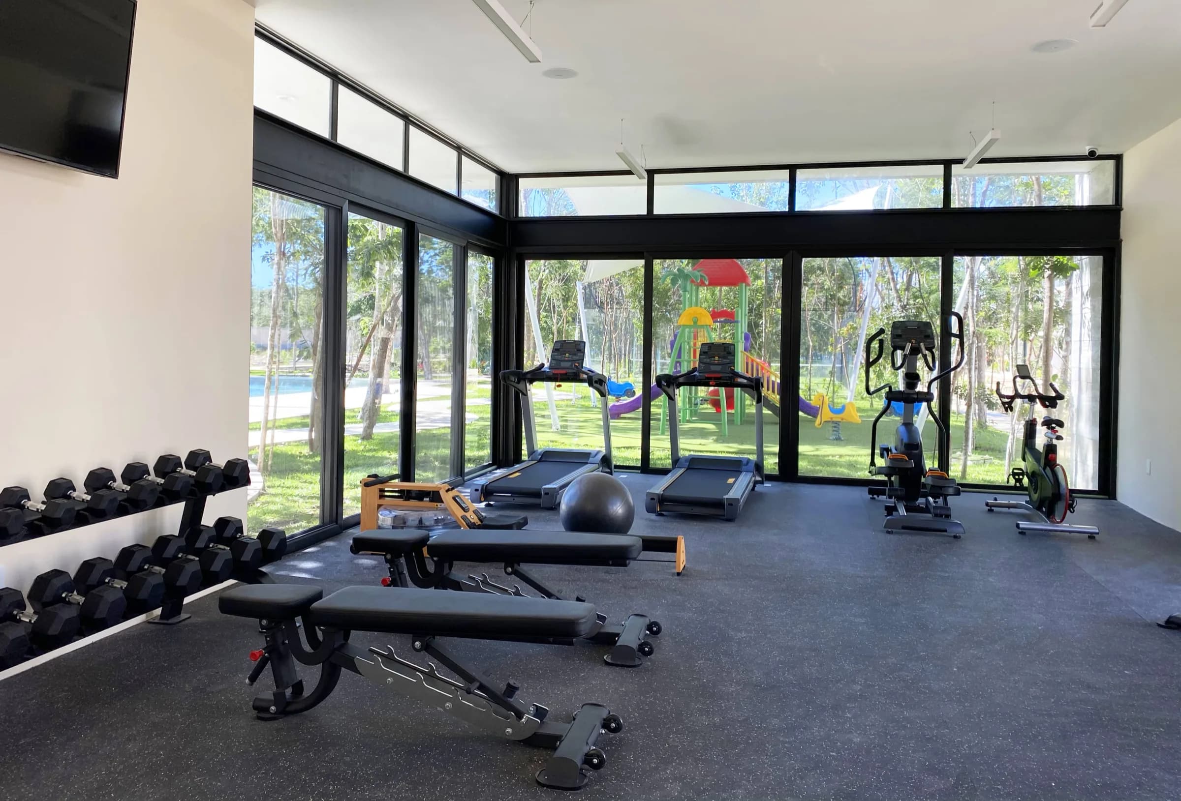 Gimnasio equipado con caminadoras y pesas